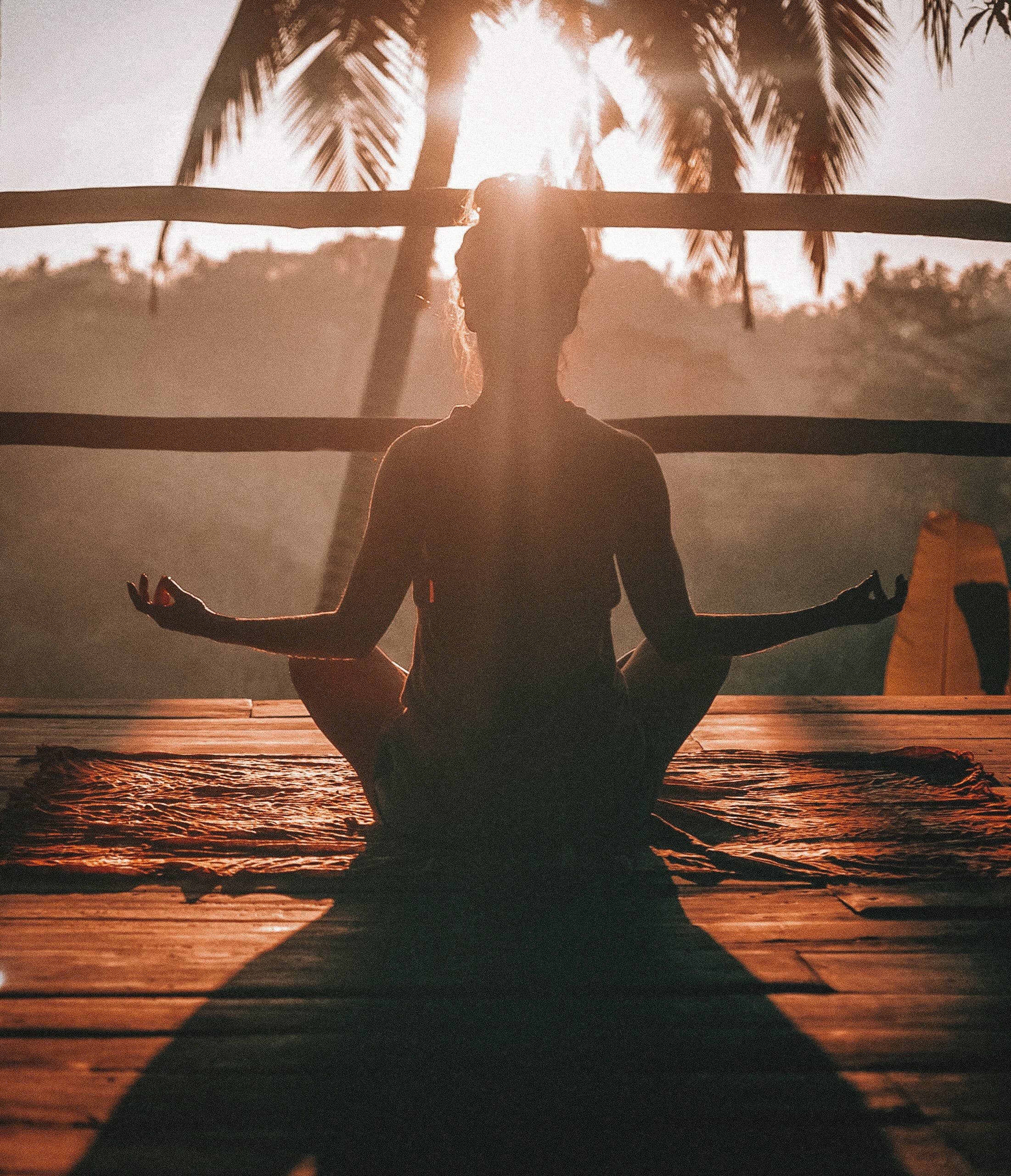 A person meditating outdoors at sunset
