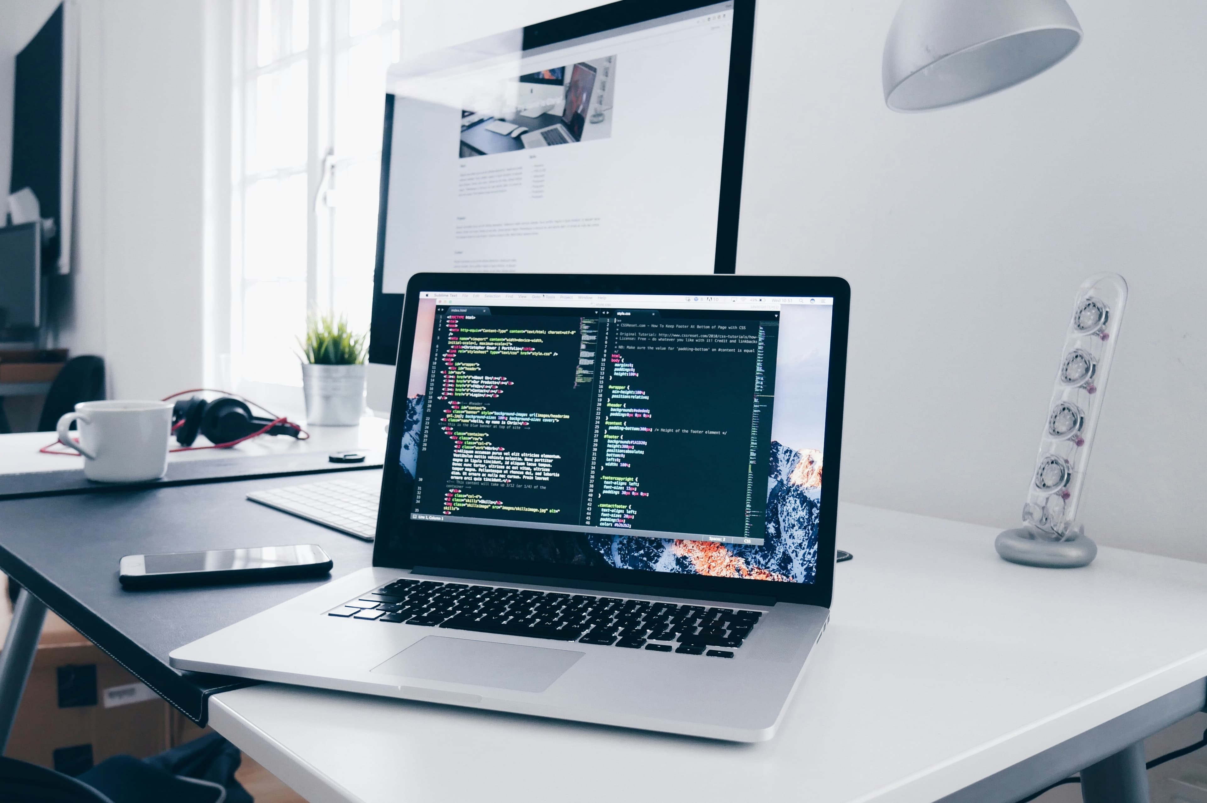 A laptop displaying code on a desk